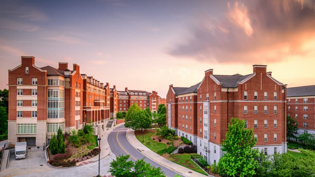 what does a property management company do? apartment complex shown at sunset