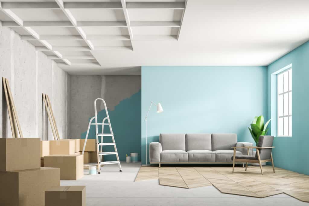 a living room with partially painted walls and half-completed floors, in the middle of renovation