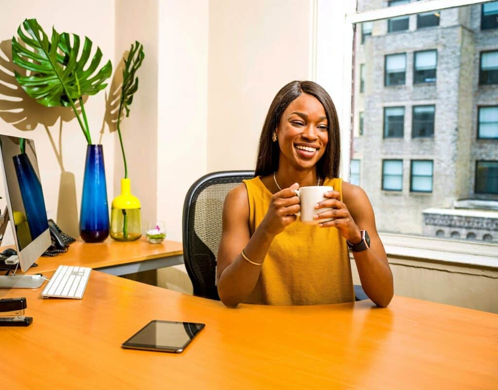 female property manager sits behind desk smiling