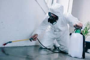 pest control worker spraying in rental property