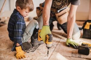 Parent fixing up their home with their young child watching