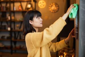 woman cleaning a picture frame in her home
