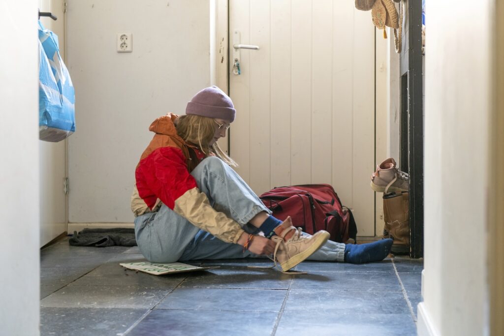girl putting on shoes in a house